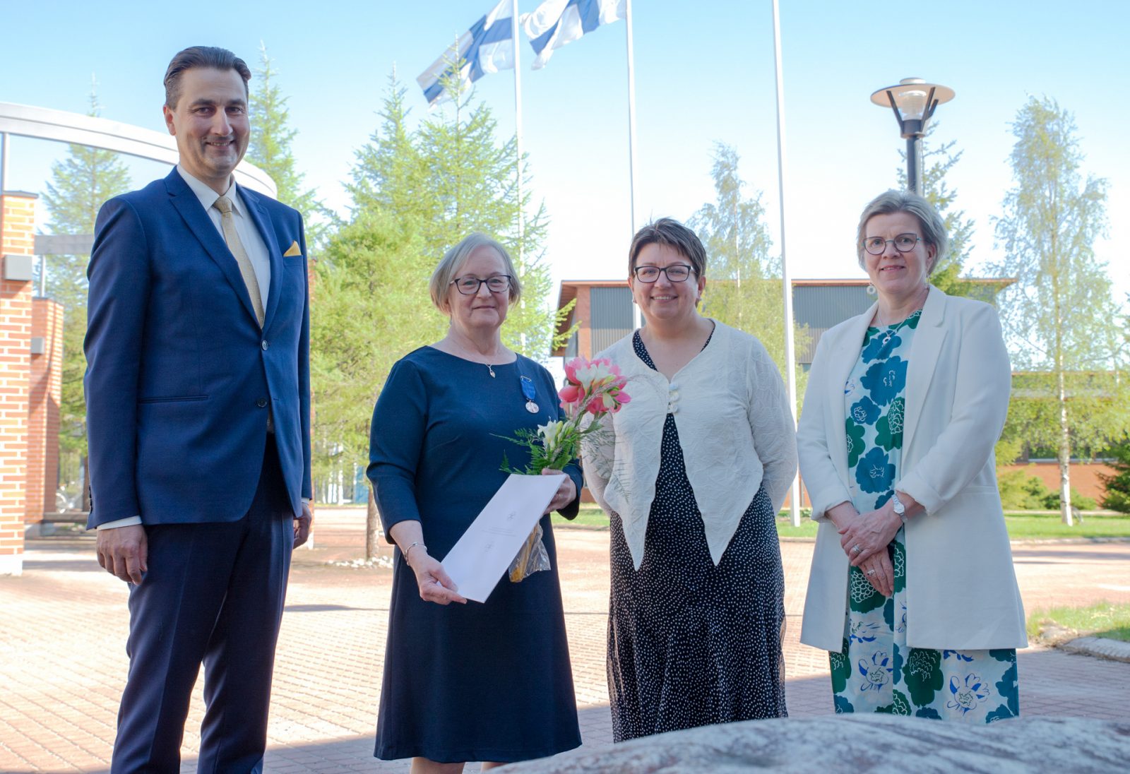 Koulutusliikelaitoksen johtaja Anssi Tuominen, kunniamerkin saaja Seija Väätäinen, KAO Kuusamon koulutuspäällikkö Jaana Pesonen ja Kuusamon kaupungin va. sivistystoimenjohtaja Anne-Koski Heikkinen.